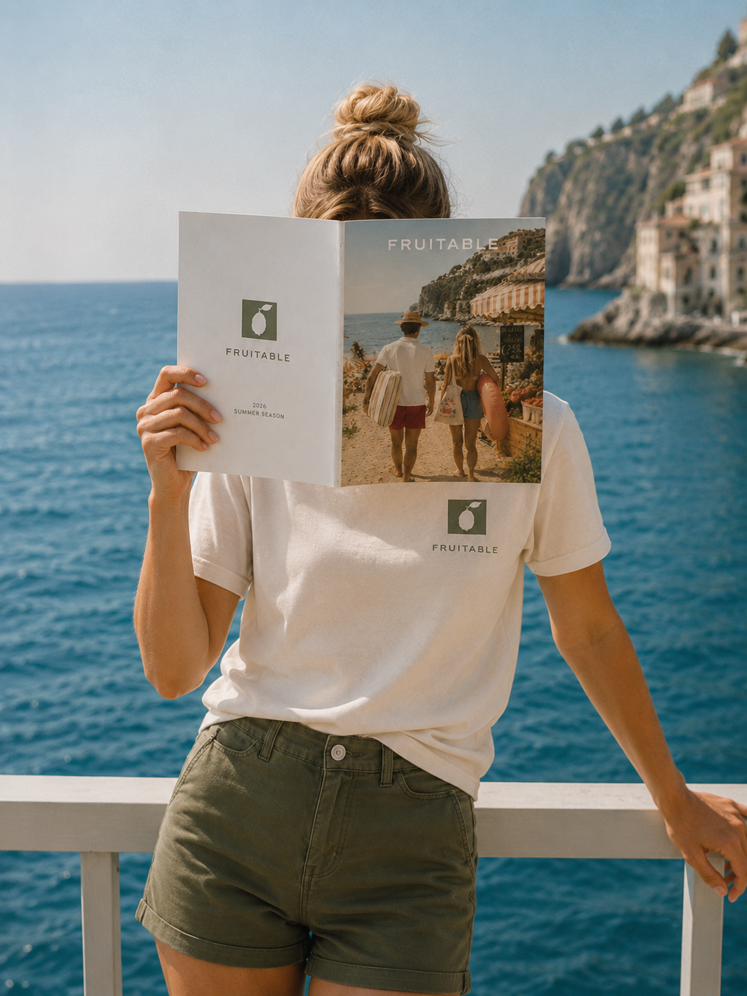 GIrl with Fruitable logo Tshirt reading a catalog on a mediterrean balcony